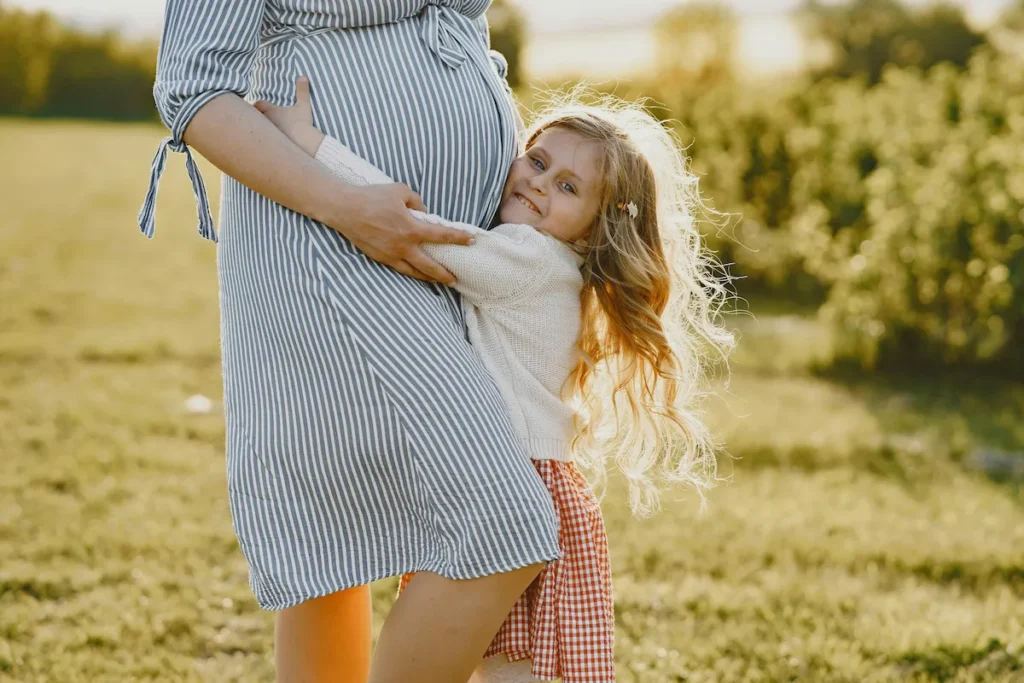 Girl hugging her pregnant mother