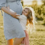 Girl hugging her pregnant mother