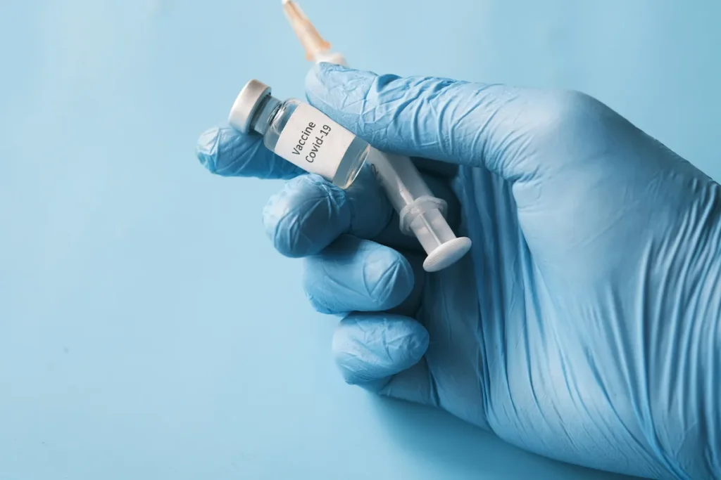Holding a vaccine vial and a syringe