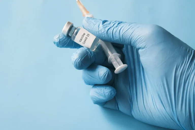 Holding a vaccine vial and a syringe