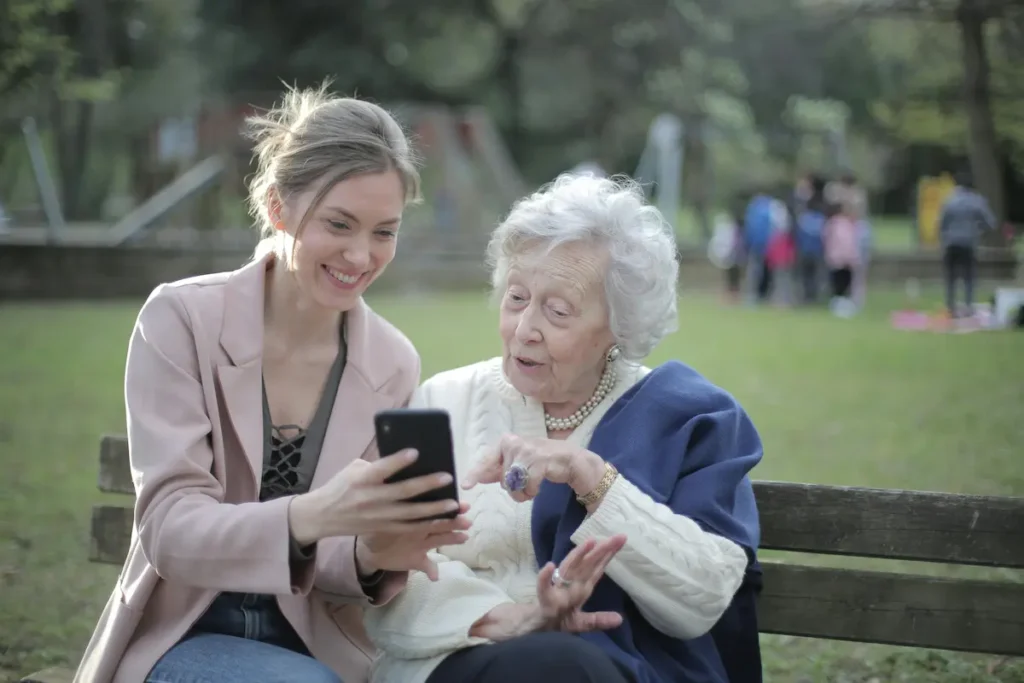 Woman showing smartphone to her mother
