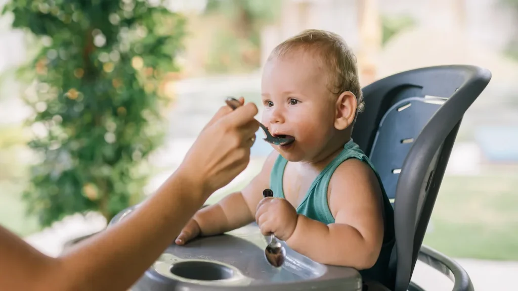 Baby eating food on a chair