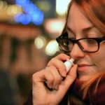 Γυναίκα που χρησιμοποιεί αποσυμφορητικό σπρέι στη μύτη