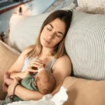 Κουρασμένη μητέρα που δίνει γάλα στο μωρό της