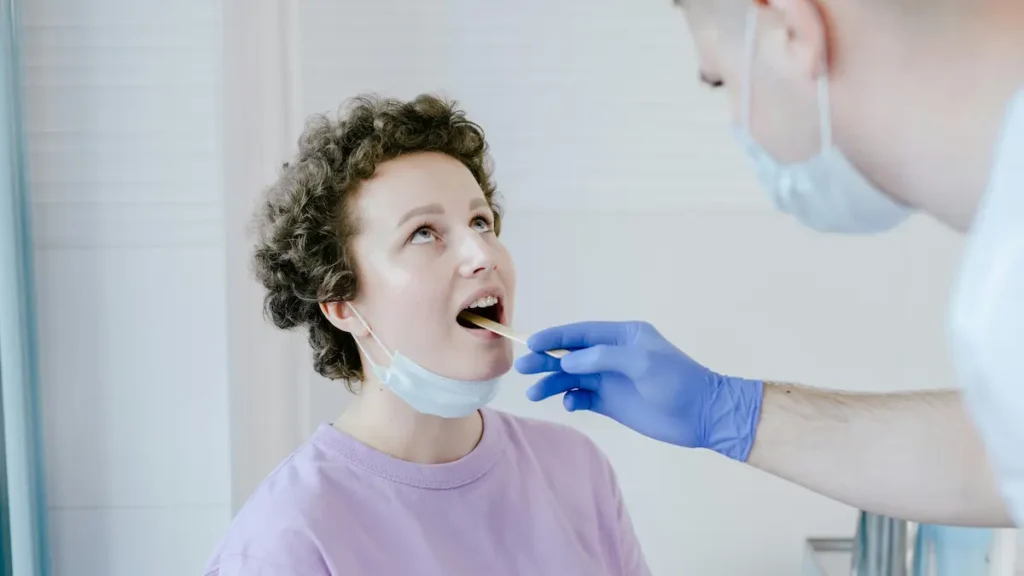 Γιατρός που εξετάζει τον φάρυγγα ασθενούς