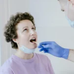 Γιατρός που εξετάζει τον φάρυγγα ασθενούς