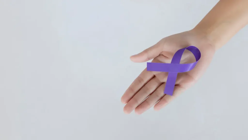 Μωβ κορδέλα ευαισθητοποίησης για τη νόσο Alzheimer στο χέρι