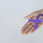 Μωβ κορδέλα ευαισθητοποίησης για τη νόσο Alzheimer στο χέρι