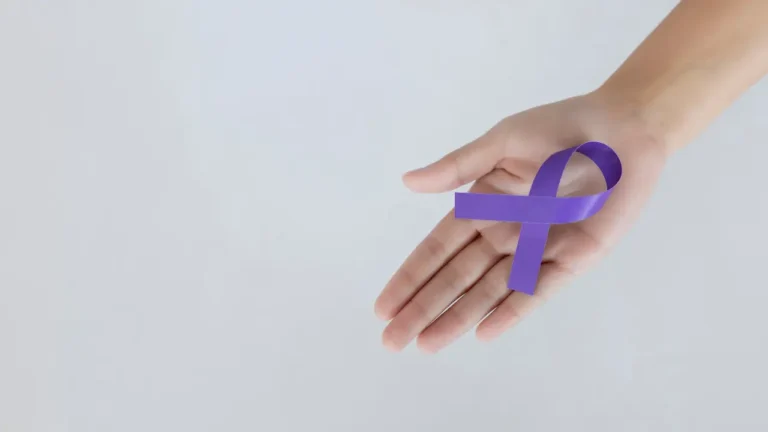 Μωβ κορδέλα ευαισθητοποίησης για τη νόσο Alzheimer στο χέρι